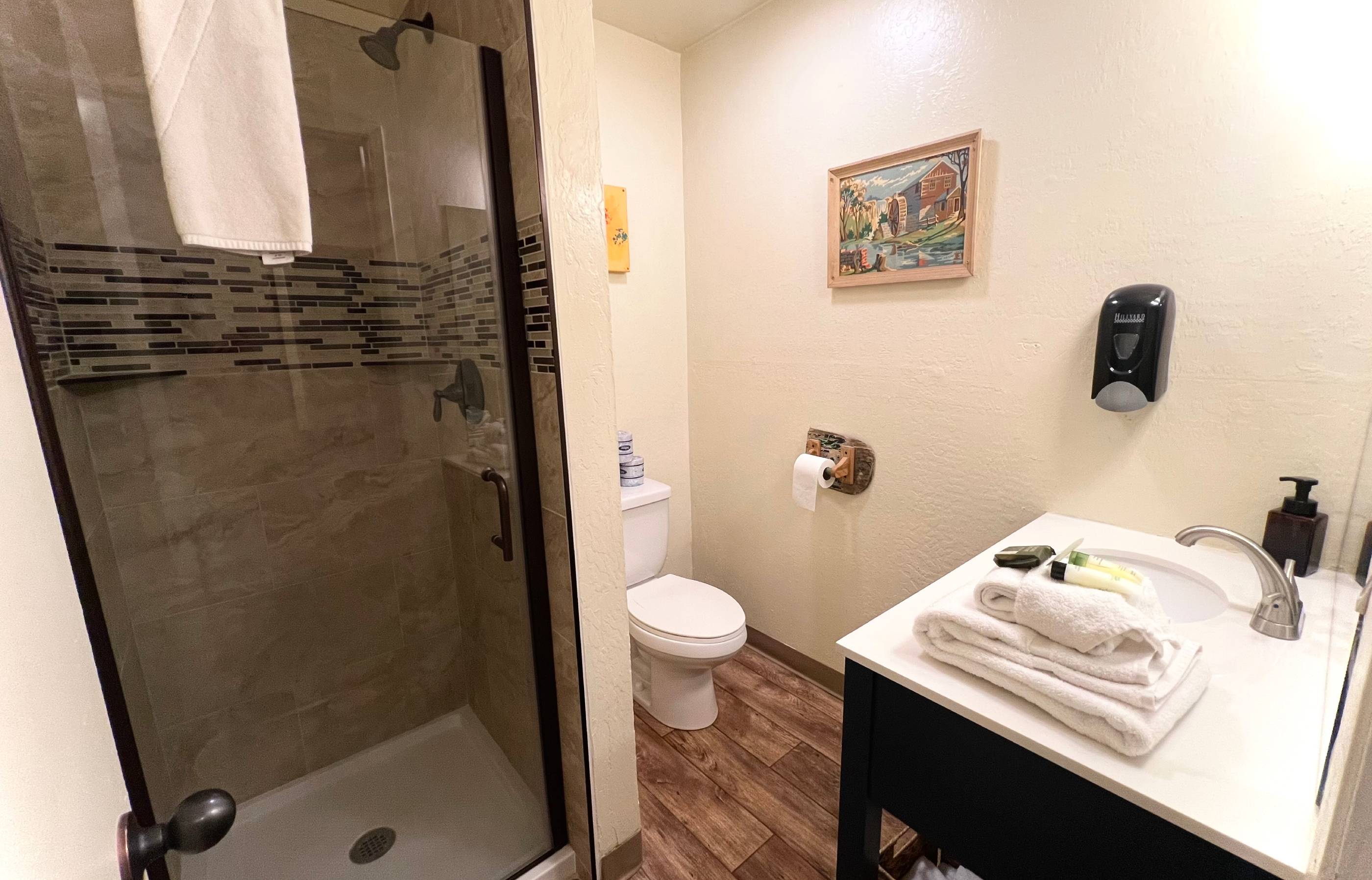 A clean bathroom with a shower, toilet, and sink